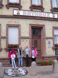 Das Bild zeigt Katarina und Joe Petritsch, Bürgermeister Ingo Kleinfelder und Julie Petritsch vor dem Rathaus von Wörrstadt