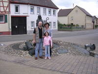 Das Bild zeigt Joe, Julie und Katarina Petritsch vor dem Denkmal der Heiligen Lioba in Schornsheim